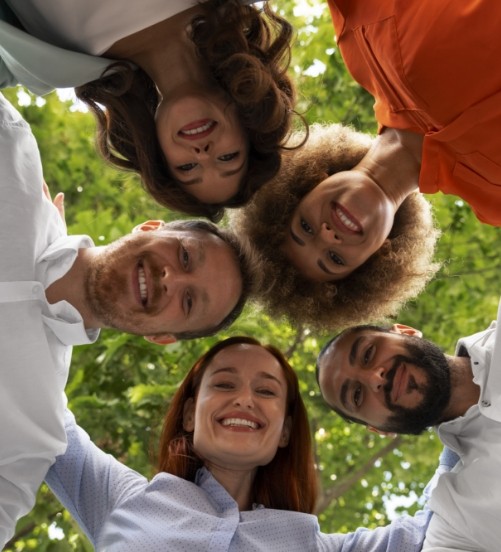 Grupo de personas sonriendo en círculo, representando la unión y comunidad de la Fundación Crecemos y Creemos